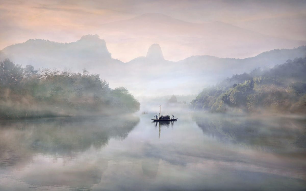 Boat on a lake in a foggy landscape